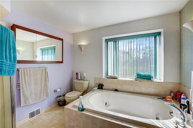 bathroom with toilet, visible vents, baseboards, a bath, and tile patterned floors