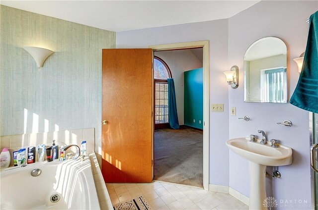 bathroom featuring a jetted tub, baseboards, and wallpapered walls