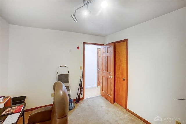 office area featuring light carpet and baseboards