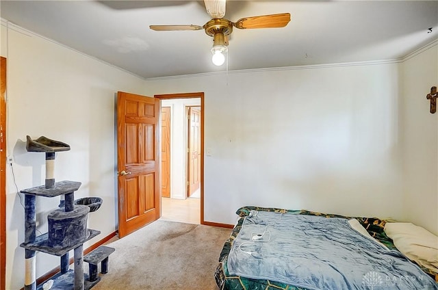 bedroom with a ceiling fan, light carpet, crown molding, and baseboards