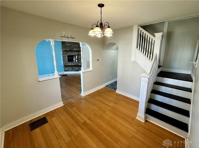 unfurnished dining area with an inviting chandelier and light hardwood / wood-style flooring