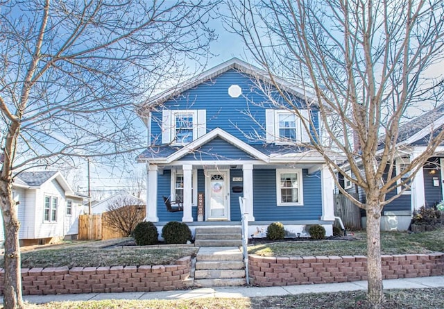 view of front of home with covered porch and fence