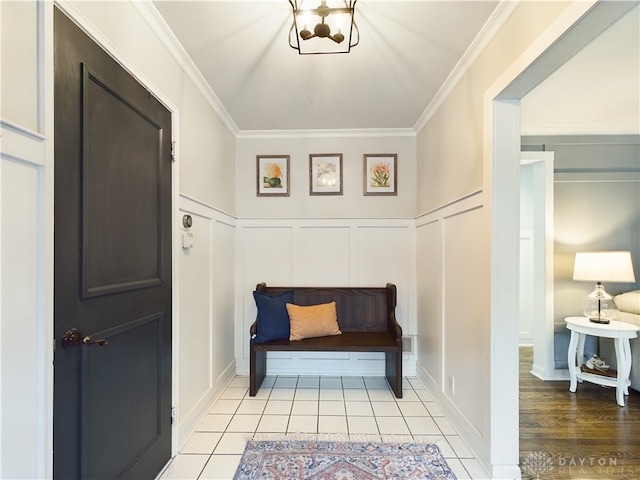 mudroom with crown molding and light tile patterned flooring