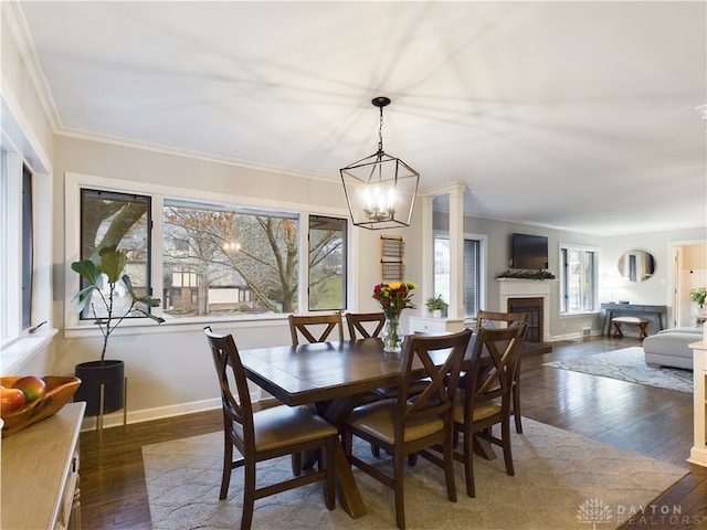 dining area featuring ornamental molding, a chandelier, and dark hardwood / wood-style flooring