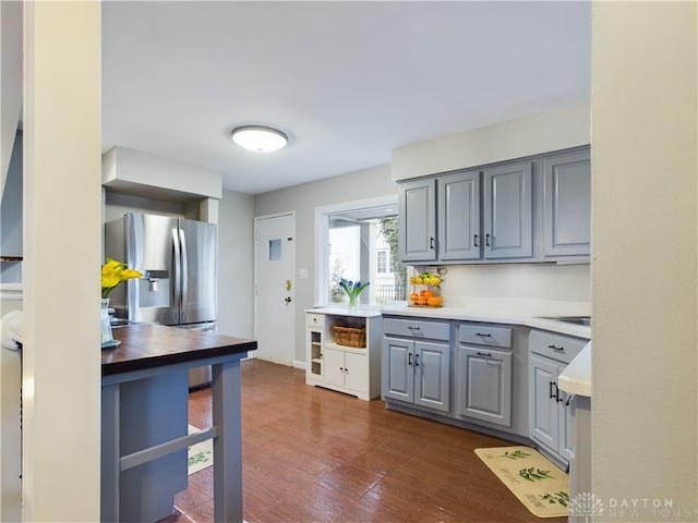 kitchen featuring gray cabinetry, stainless steel fridge, and dark hardwood / wood-style flooring