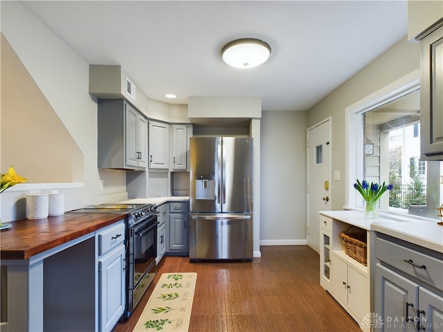 kitchen with gray cabinets, butcher block countertops, dark wood-type flooring, stainless steel refrigerator with ice dispenser, and black electric range