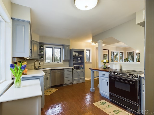 kitchen featuring dark wood-type flooring, sink, ornate columns, electric range, and dishwasher