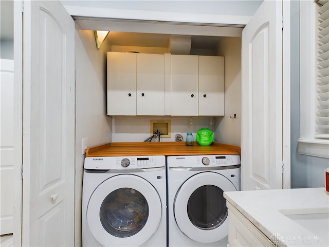 washroom featuring washing machine and dryer and cabinets