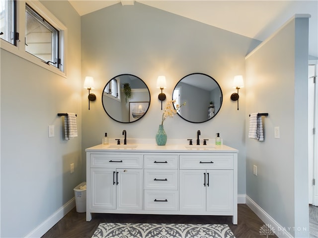 bathroom featuring parquet floors, vanity, and vaulted ceiling