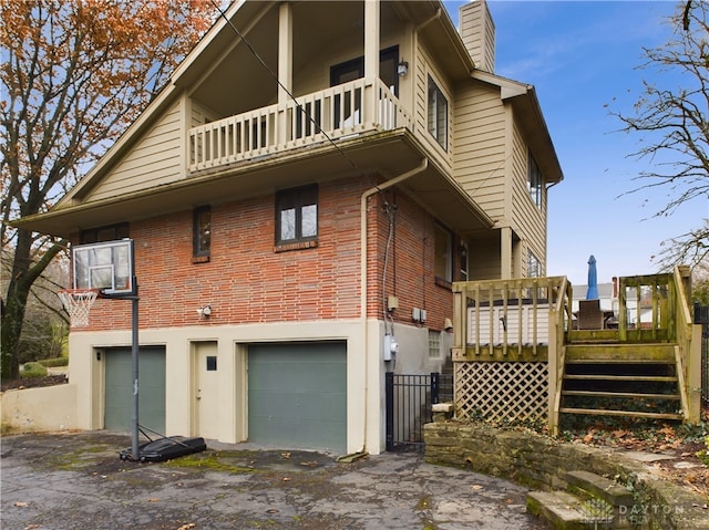 rear view of property with a garage and a balcony