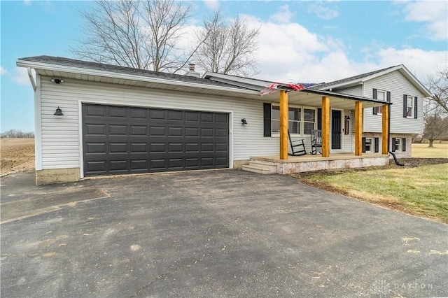 view of front facade featuring a garage, a front lawn, and covered porch