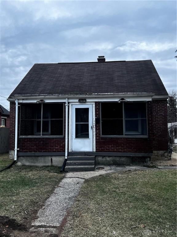 bungalow-style home with a front yard