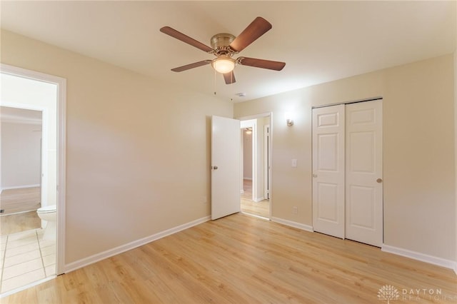 unfurnished bedroom featuring connected bathroom, a closet, ceiling fan, and light wood-type flooring