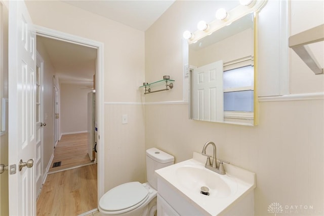 bathroom featuring vanity, wood-type flooring, and toilet