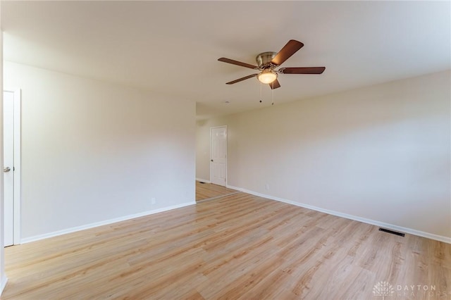 empty room with ceiling fan and light hardwood / wood-style flooring