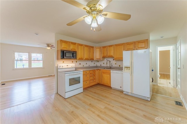 kitchen featuring sink, white appliances, light hardwood / wood-style flooring, ceiling fan, and backsplash