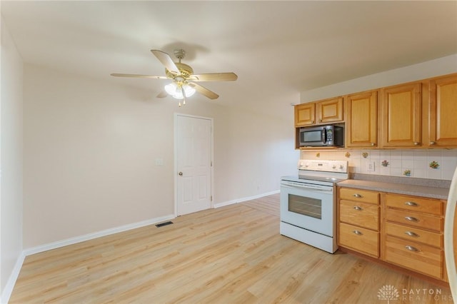 kitchen with ceiling fan, electric range, light wood-type flooring, and decorative backsplash