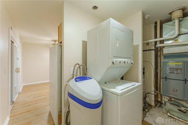 washroom featuring stacked washer / dryer and light hardwood / wood-style flooring