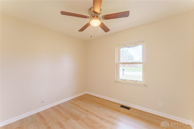 empty room with ceiling fan and light hardwood / wood-style flooring