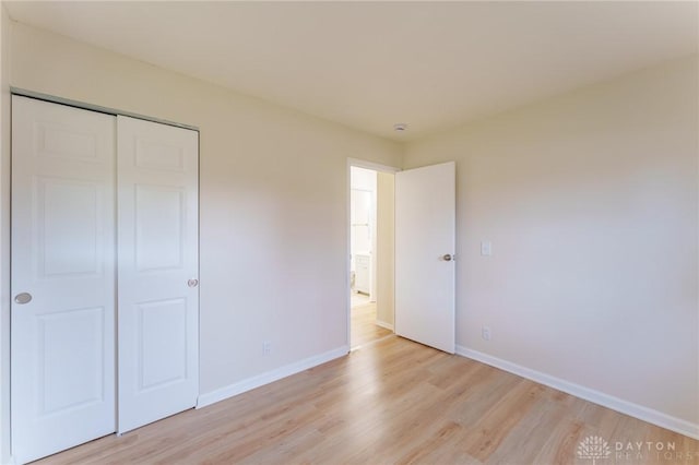 unfurnished bedroom featuring light hardwood / wood-style flooring and a closet