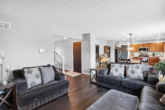 living room with dark hardwood / wood-style floors and a textured ceiling