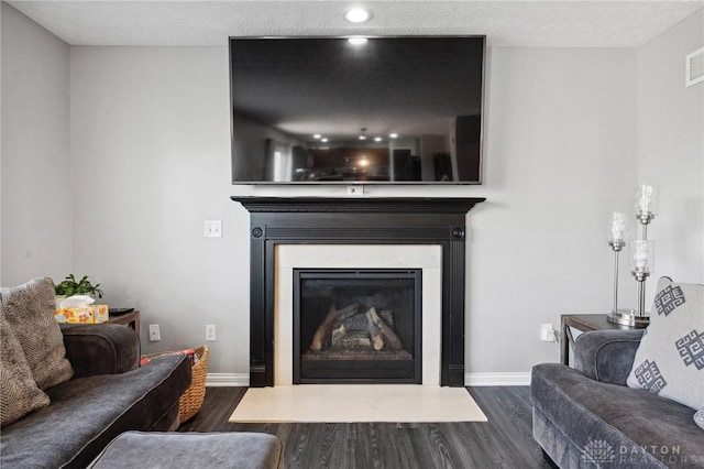 living room with dark hardwood / wood-style floors and a textured ceiling