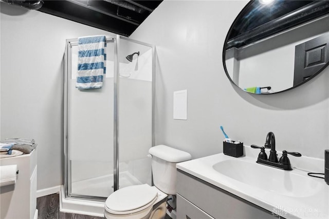 bathroom featuring an enclosed shower, vanity, hardwood / wood-style floors, and toilet