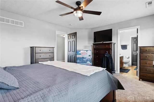 carpeted bedroom with ceiling fan and ensuite bathroom