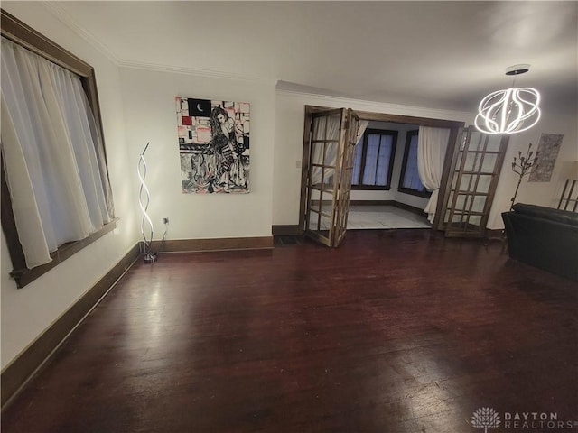 interior space with an inviting chandelier, crown molding, dark hardwood / wood-style floors, and french doors