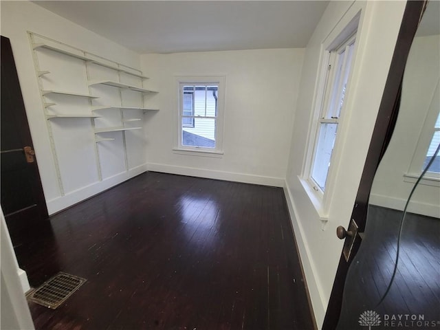 unfurnished room with dark wood-type flooring