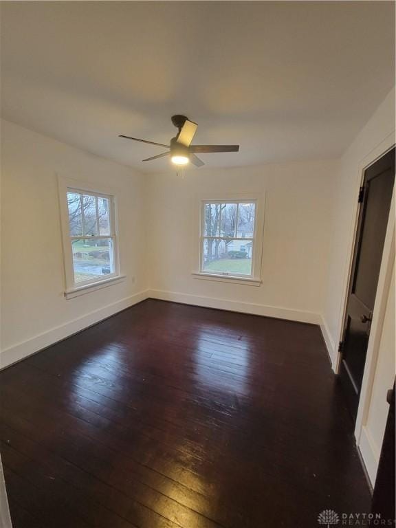 empty room with ceiling fan and dark hardwood / wood-style flooring