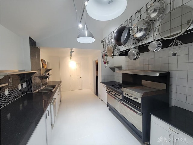 kitchen featuring lofted ceiling, sink, white cabinetry, tasteful backsplash, and pendant lighting