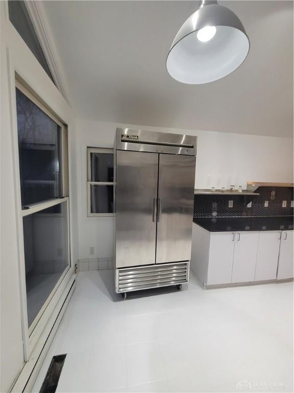 kitchen with white cabinetry and built in fridge