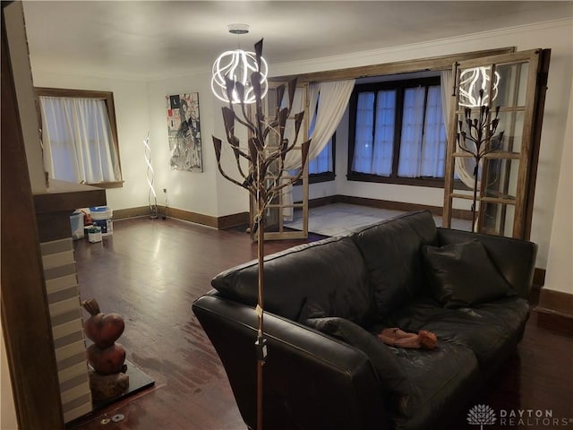 living room featuring ornamental molding, dark hardwood / wood-style floors, and a chandelier