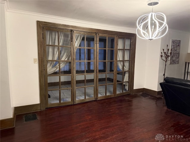 dining room with an inviting chandelier, ornamental molding, and dark hardwood / wood-style floors