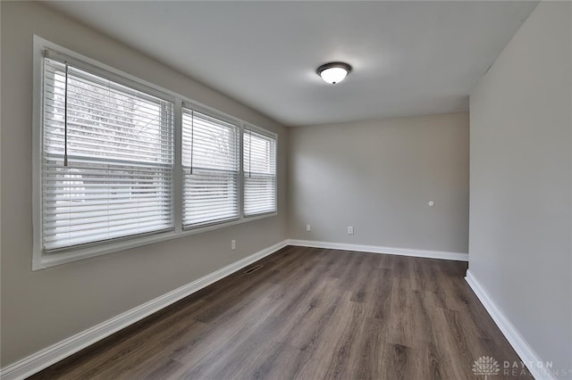 unfurnished room with dark wood-type flooring