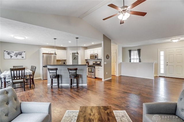 living room featuring lofted ceiling with beams, dark hardwood / wood-style floors, and ceiling fan