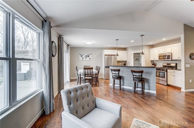 living room with vaulted ceiling and light hardwood / wood-style flooring