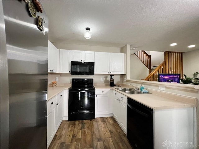 kitchen featuring sink, white cabinets, black appliances, dark wood-type flooring, and a textured ceiling