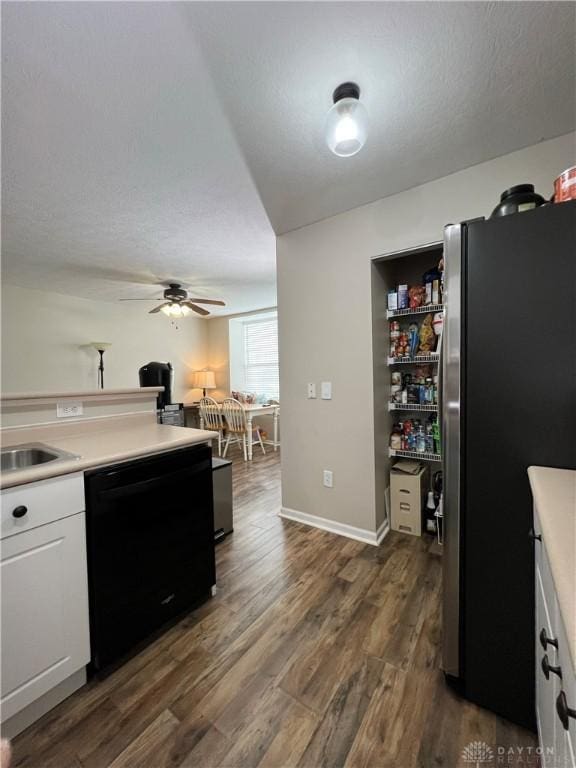 kitchen with dark hardwood / wood-style floors, black dishwasher, white cabinets, stainless steel fridge, and ceiling fan