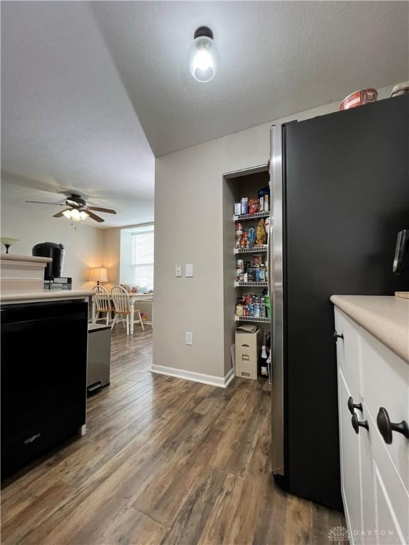 kitchen featuring hardwood / wood-style flooring, ceiling fan, stainless steel fridge, and black dishwasher