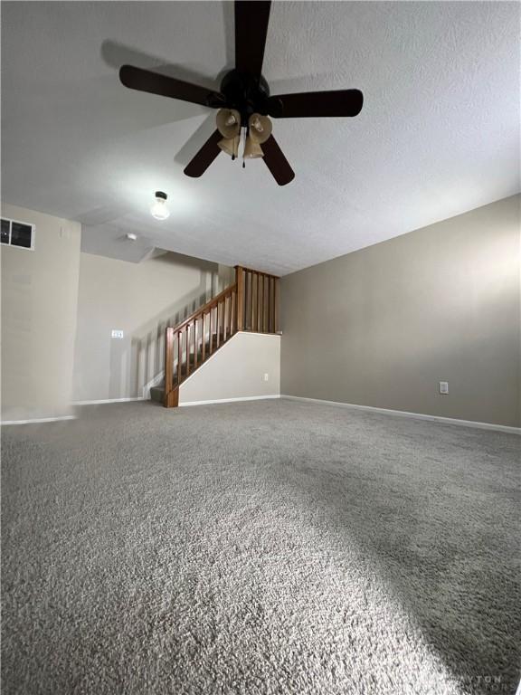 carpeted empty room featuring a textured ceiling