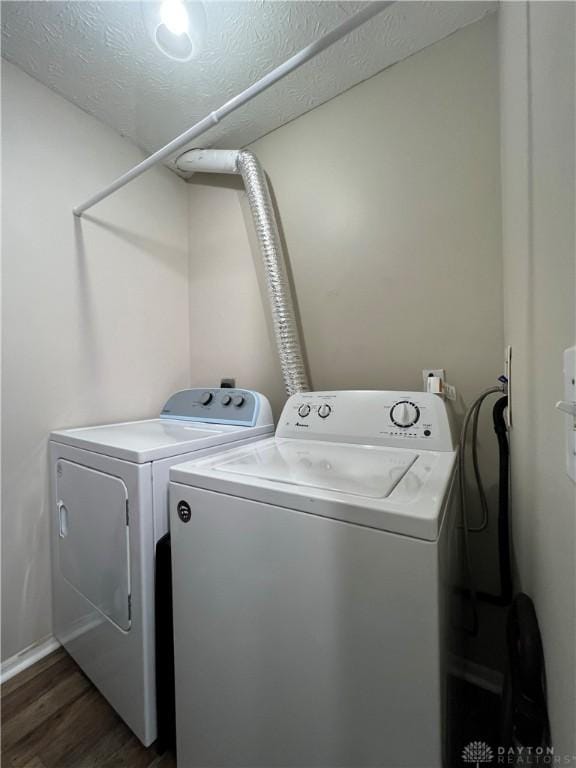 laundry room featuring a textured ceiling, washing machine and clothes dryer, and dark hardwood / wood-style flooring