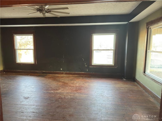 spare room with ceiling fan, dark hardwood / wood-style flooring, and a wealth of natural light