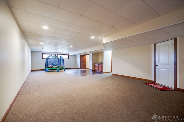 interior space with a drop ceiling and carpet floors