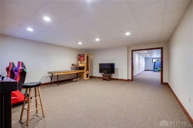 rec room featuring carpet flooring and a drop ceiling