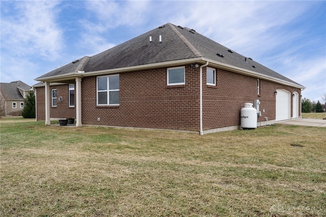 back of house featuring a garage and a lawn