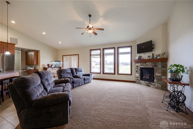 carpeted living room featuring a stone fireplace, high vaulted ceiling, and ceiling fan