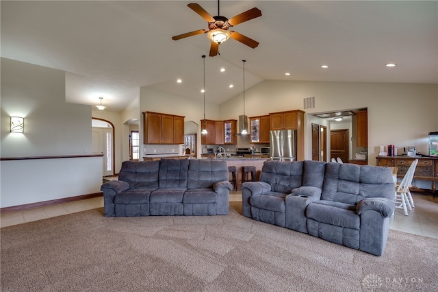 living room featuring light tile patterned flooring, ceiling fan, sink, and high vaulted ceiling