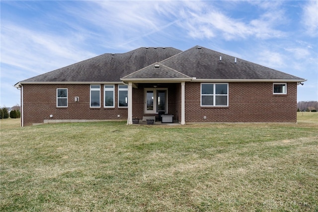 back of property with a yard and a patio area